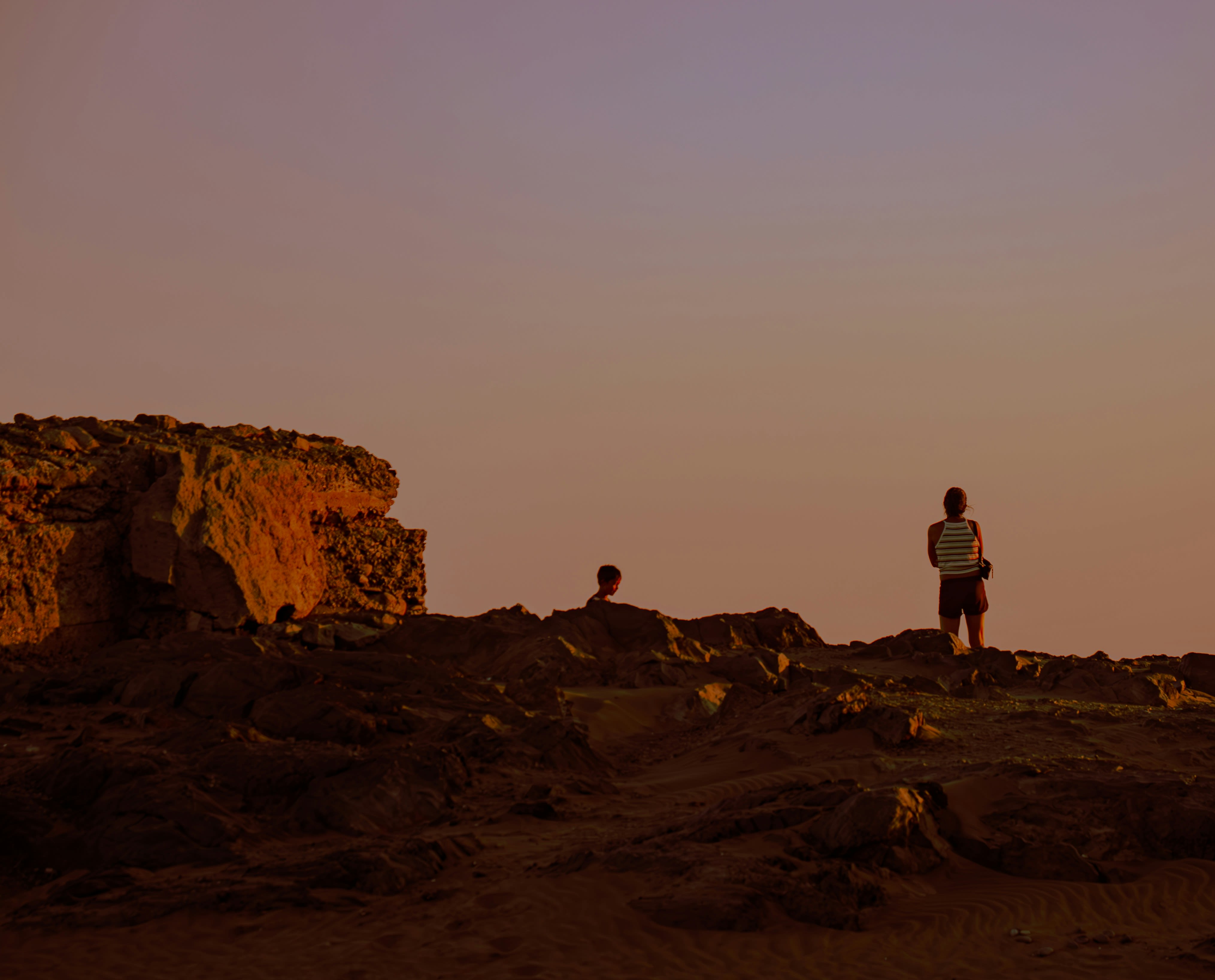 a couple of people standing on top of a rocky hillside